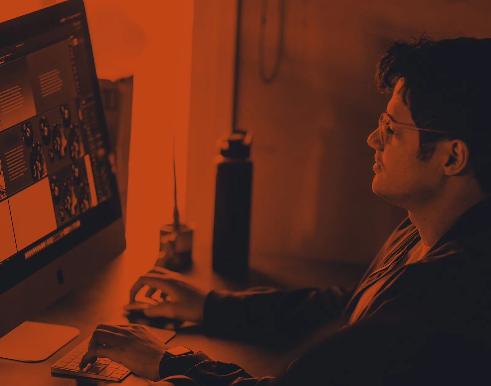 A designer at a desktop monitor editing a bold, color-blocked storefront layout